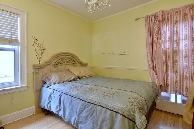 bedroom featuring a chandelier, hardwood / wood-style floors, baseboards, and crown molding