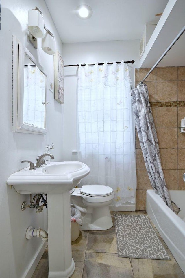 bathroom with shower / tub combo, a sink, and toilet