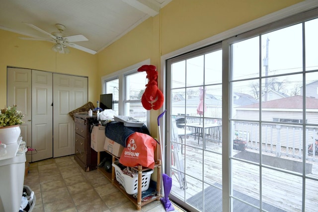 doorway to outside featuring light tile patterned floors, a ceiling fan, vaulted ceiling, and crown molding