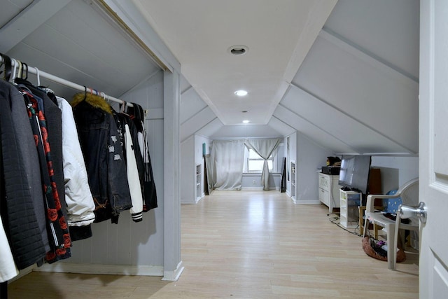 interior space with vaulted ceiling, baseboards, and wood finished floors