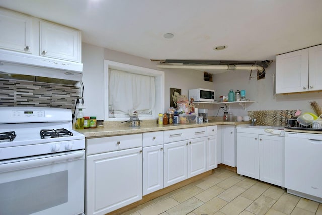 kitchen featuring white appliances, tasteful backsplash, white cabinets, light countertops, and under cabinet range hood