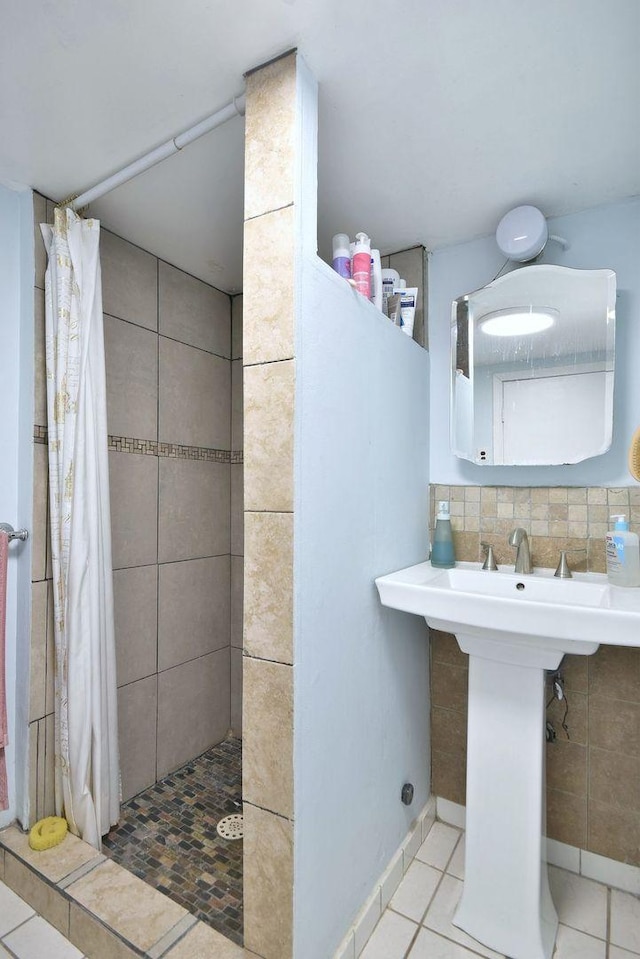 full bath with tile patterned flooring, a tile shower, and backsplash