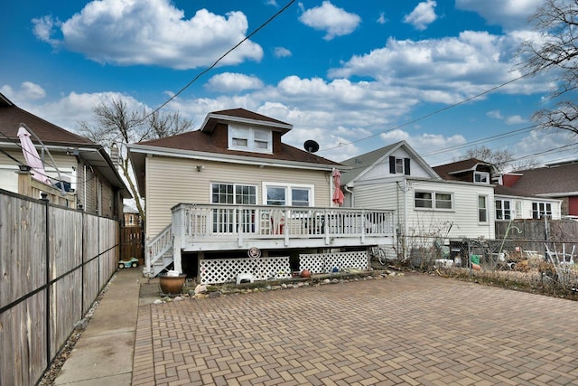 rear view of property with fence and a wooden deck