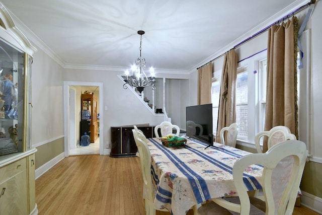 dining area featuring light wood-style flooring, baseboards, a chandelier, and crown molding