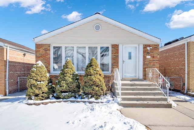 view of front of property featuring brick siding and fence