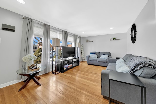 living room with light wood-style flooring, baseboards, and recessed lighting