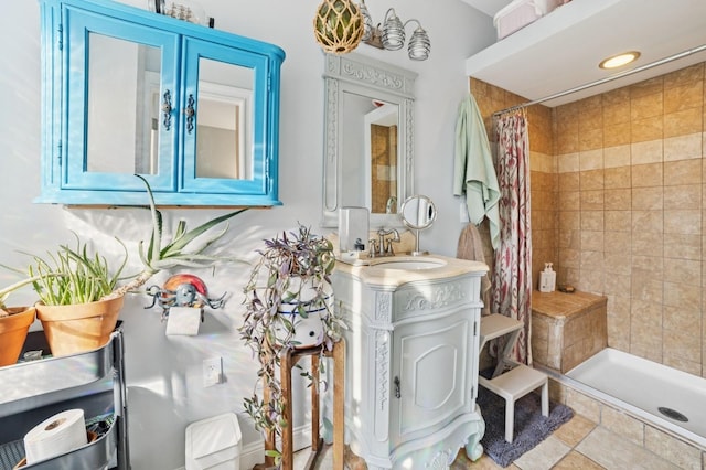 full bathroom with a tile shower and vanity