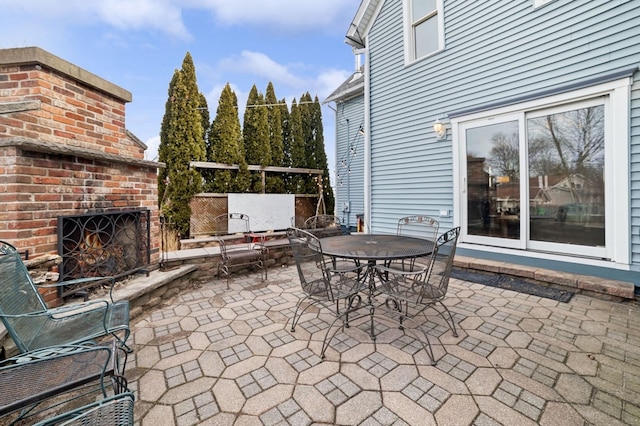 view of patio / terrace with an outdoor brick fireplace and outdoor dining area