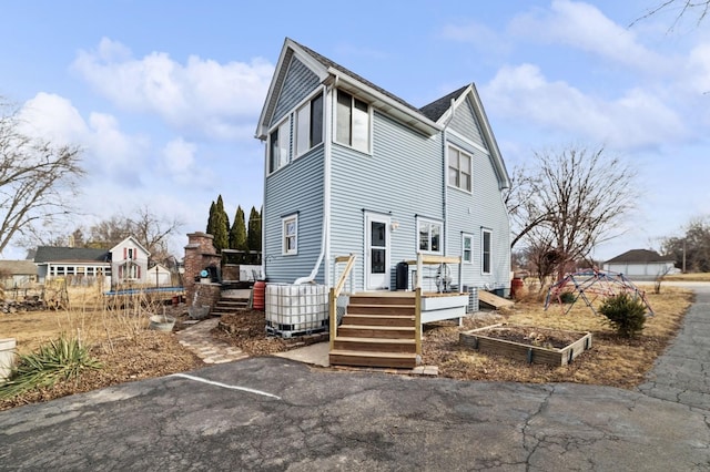 exterior space featuring a garden, a trampoline, and a wooden deck