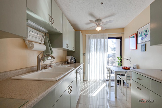 kitchen with a textured ceiling, a sink, a ceiling fan, light countertops, and dishwasher