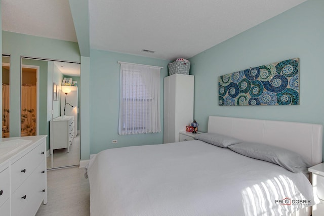 bedroom featuring light wood-type flooring and visible vents