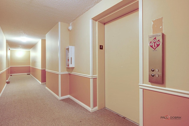 corridor featuring a textured ceiling, carpet flooring, and baseboards