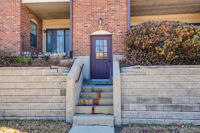 doorway to property featuring brick siding