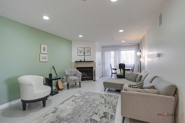 living room featuring a fireplace with flush hearth, recessed lighting, and baseboards