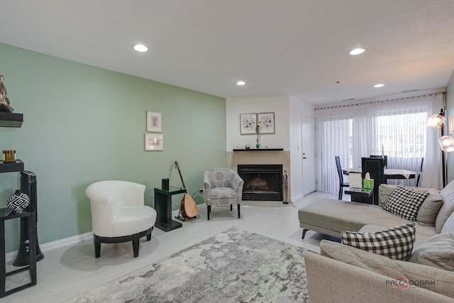 living room with baseboards, a fireplace with flush hearth, and recessed lighting