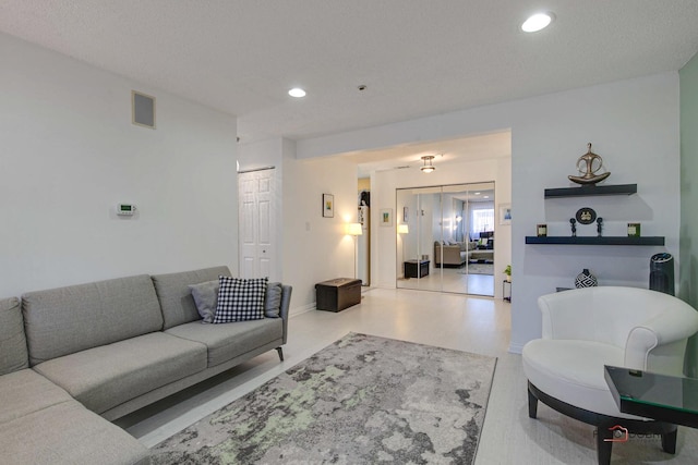 living room featuring baseboards, visible vents, and recessed lighting