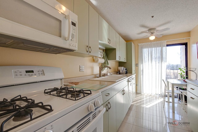 kitchen with white appliances, ceiling fan, light countertops, a textured ceiling, and a sink