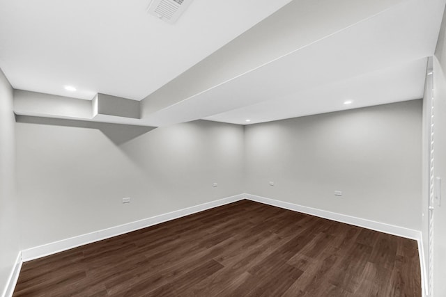 finished below grade area featuring visible vents, baseboards, dark wood-style flooring, and recessed lighting