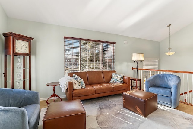 living area with lofted ceiling, baseboards, and wood finished floors