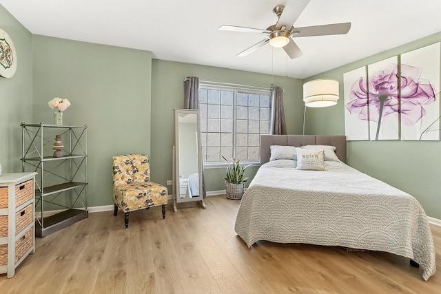 bedroom with ceiling fan, baseboards, and wood finished floors