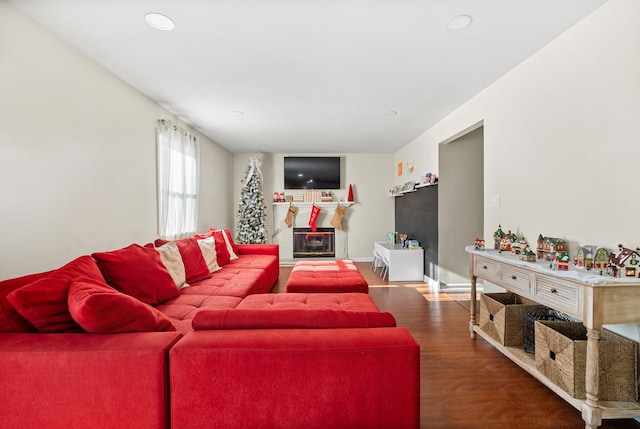 living area featuring a wood stove, baseboards, and wood finished floors