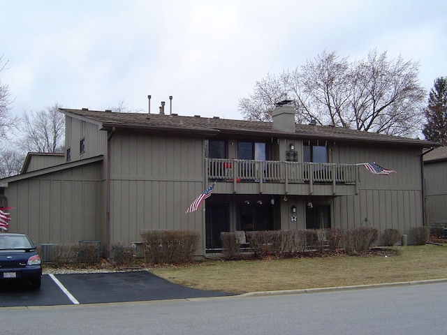 exterior space with a balcony and a chimney