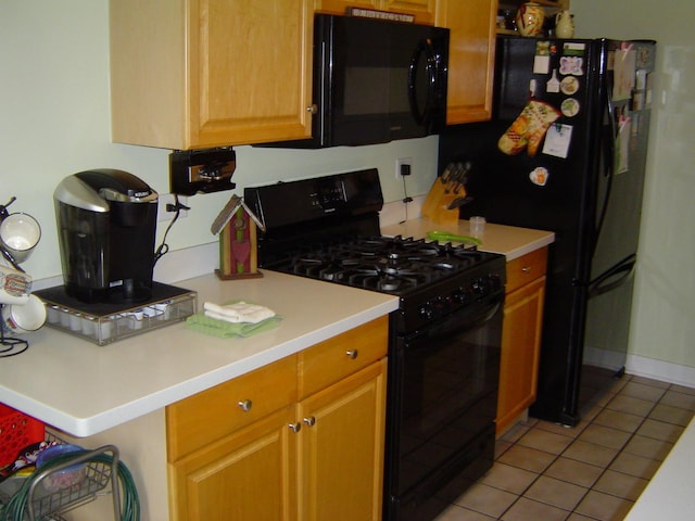 kitchen with light tile patterned floors, baseboards, black appliances, and light countertops