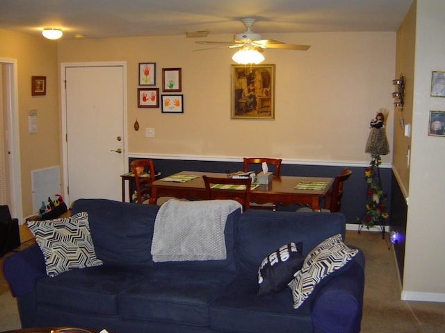 living area featuring carpet flooring and a ceiling fan