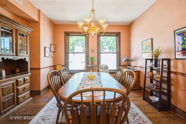 dining room featuring baseboards, dark wood finished floors, and a notable chandelier