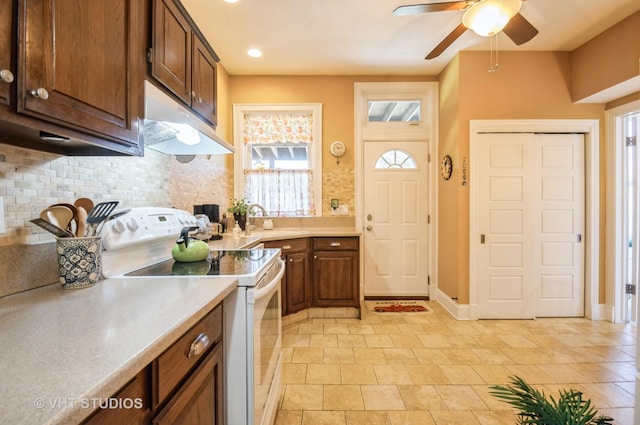 kitchen featuring ceiling fan, under cabinet range hood, electric stove, light countertops, and backsplash