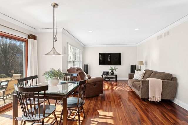 dining space featuring crown molding, wood finished floors, visible vents, and baseboards