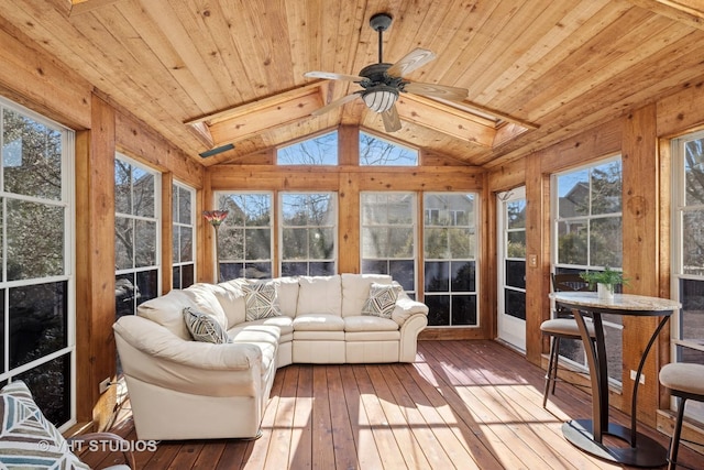 sunroom / solarium with ceiling fan, vaulted ceiling with skylight, plenty of natural light, and wooden ceiling