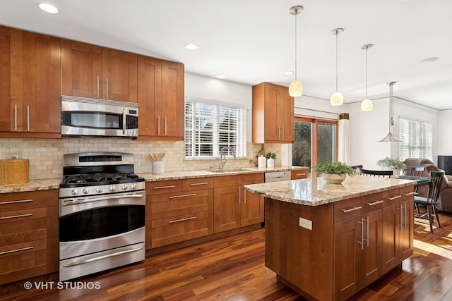 kitchen with dark wood-type flooring, a sink, appliances with stainless steel finishes, light stone countertops, and tasteful backsplash