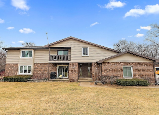 traditional home featuring brick siding, a front yard, and a balcony