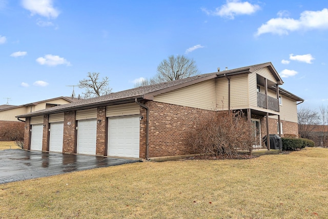 view of property exterior with a balcony, community garages, a lawn, and brick siding