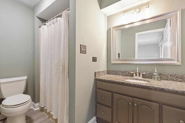 full bath featuring toilet, curtained shower, baseboards, and vanity