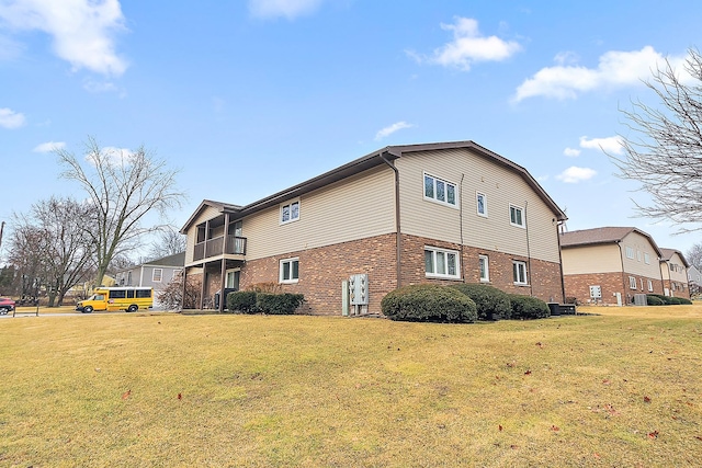 view of property exterior with brick siding and a lawn