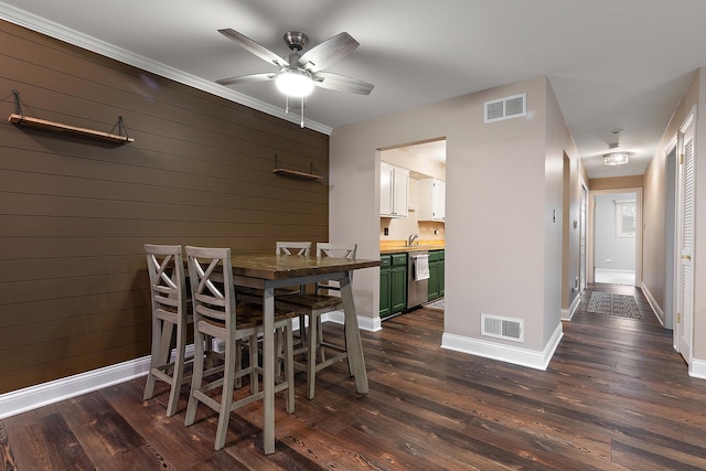 dining area featuring wood walls, visible vents, and dark wood finished floors