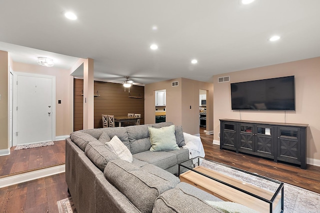 living area featuring baseboards, visible vents, dark wood-style flooring, and recessed lighting