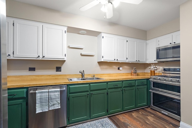 kitchen with stainless steel appliances, butcher block counters, dark wood-style flooring, a sink, and white cabinets