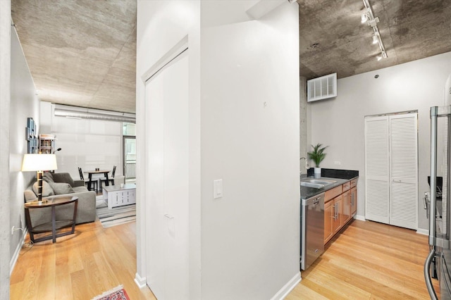 interior space featuring stainless steel dishwasher, a sink, visible vents, and light wood-style floors