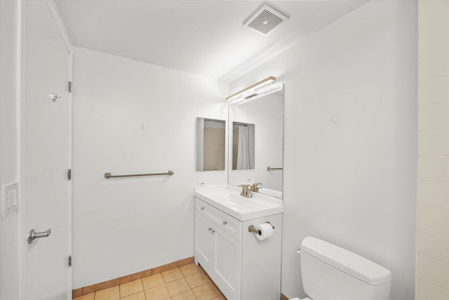 half bath with visible vents, toilet, vanity, baseboards, and tile patterned floors