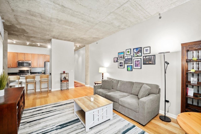 living area featuring light wood-type flooring and baseboards