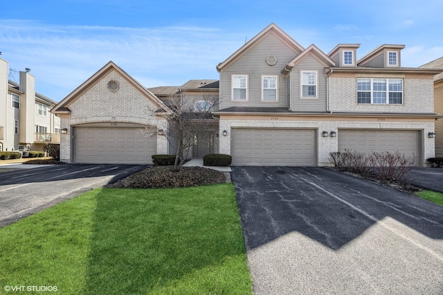 townhome / multi-family property with brick siding and a front yard