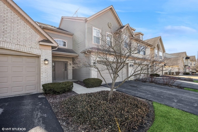 view of front of property featuring brick siding, a residential view, and driveway