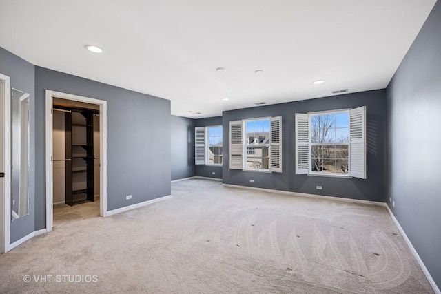 carpeted spare room featuring recessed lighting, visible vents, and baseboards