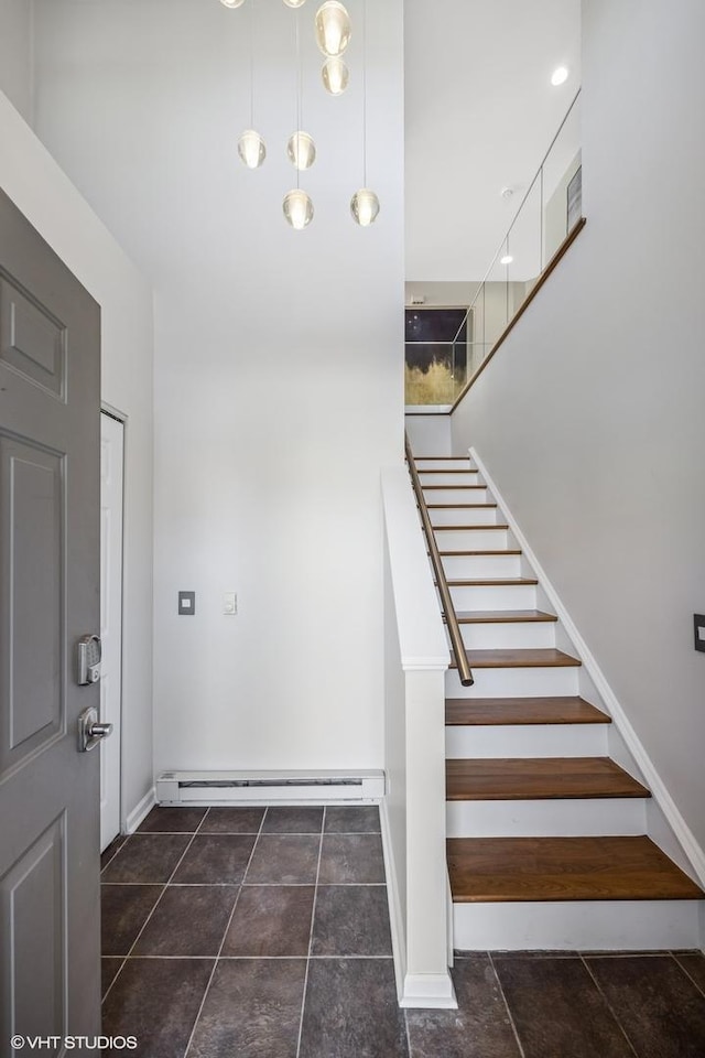 stairway featuring baseboard heating and baseboards