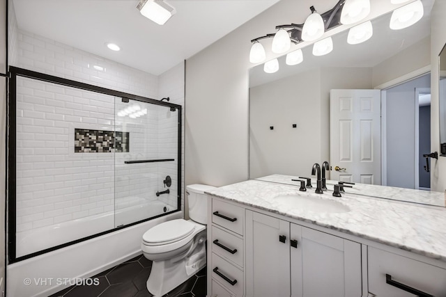 bathroom with tile patterned flooring, toilet, vanity, and combined bath / shower with glass door