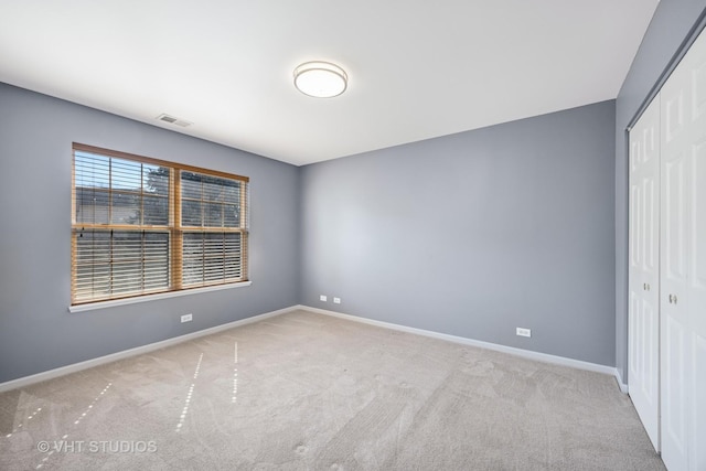 unfurnished bedroom featuring carpet, baseboards, visible vents, and a closet