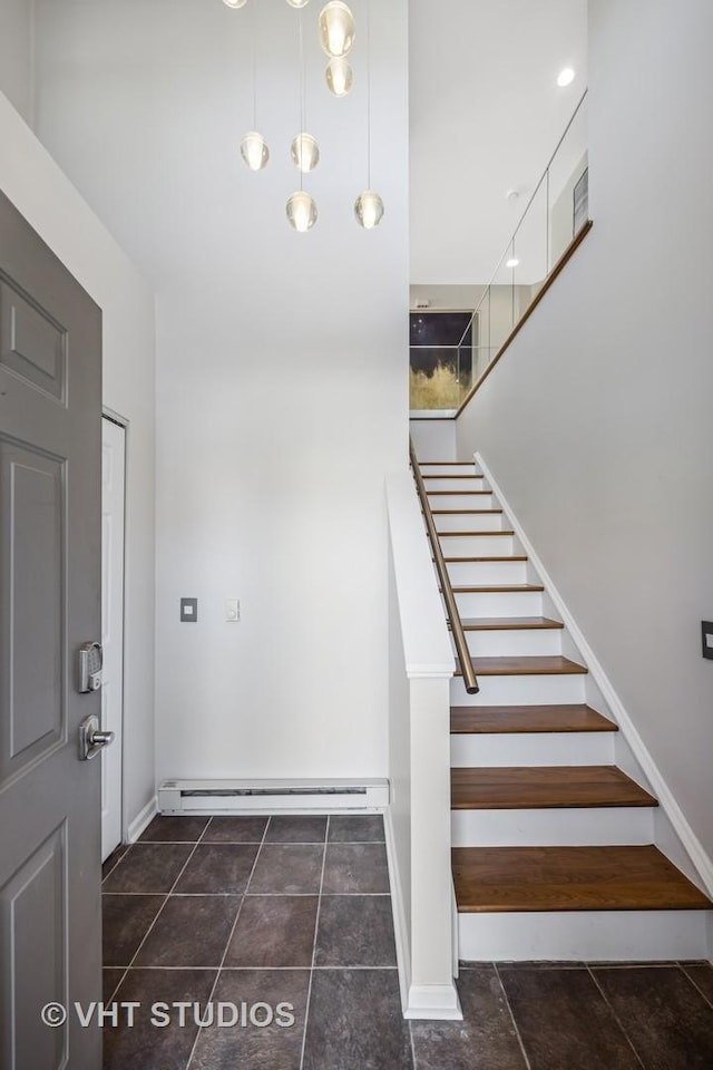 stairway with baseboard heating and baseboards